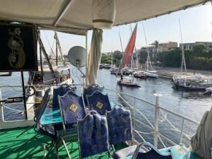 a boat in a body of water with boats at Floating Hotel- Happy Nile Boat in Luxor