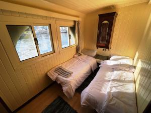 two beds in a room with two windows at Floating Hotel- Happy Nile Boat in Luxor