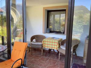 een patio met een tafel en stoelen op een balkon bij Double room with a kitchenette in a beautiful surrounding in Sautens