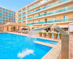 una piscina con un tobogán de agua frente a un hotel en ALEGRIA Maripins, en Malgrat de Mar
