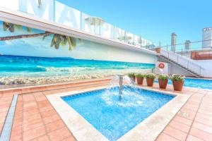 a swimming pool with a water fountain in front of a building at ALEGRIA Maripins in Malgrat de Mar