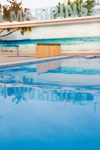 a swimming pool with blue water in front of a building at ALEGRIA Maripins in Malgrat de Mar