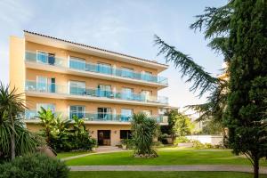 un edificio de apartamentos con jardín frente a él en ALEGRIA Maripins, en Malgrat de Mar