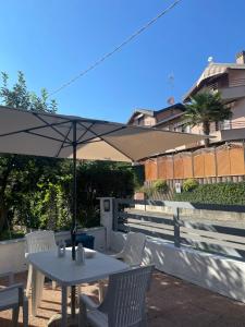 Ronago的住宿－B&B FIOR DI CAMPO，一张白色的桌子和椅子,配有雨伞