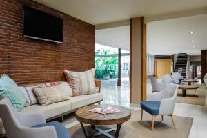 a living room with a couch and a brick wall at ALEGRIA Maripins in Malgrat de Mar