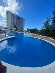 una gran piscina azul con un edificio alto en el fondo en SWEET PARADISE, en Playa Paraiso
