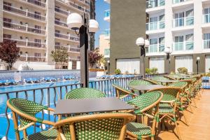 a row of tables and chairs on a balcony with a pool at ALEGRIA Cartago Nova in Malgrat de Mar