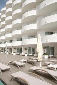 an empty courtyard of a building with chairs and an umbrella at ALEGRIA Mar Mediterrania - Adults Only 4*Sup in Santa Susanna