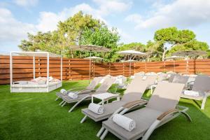 a group of lawn chairs and umbrellas on the grass at ALEGRIA Mar Mediterrania - Adults Only 4*Sup in Santa Susanna