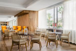 a dining room with tables and chairs and windows at ALEGRIA Caprici Verd in Santa Susanna