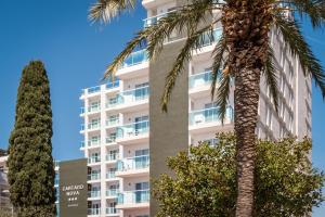 un palmier devant un bâtiment dans l'établissement Hotel Cartago Nova by ALEGRIA, à Malgrat de Mar