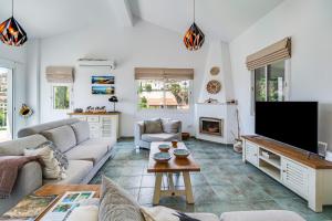 a living room with a couch and a tv at The Bridge Villa by Ezoria Villas in Coral Bay