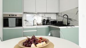 a bowl of fruit on a table in a kitchen at Linden Apartman 104 - Adults Only in Mosonmagyaróvár