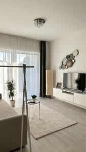 een witte woonkamer met een bank en een tv bij Linden Apartman 104 - Adults Only in Mosonmagyaróvár