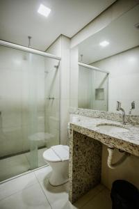 y baño con aseo, lavabo y ducha. en Lagoa Flat Hotel, en Lagoa da Prata