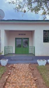 a building with a green door in front of it at Hostelito Room in Kigali