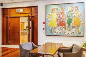 a room with a table and chairs and a painting on the wall at Hotel Dom Goncalo & Spa in Fátima