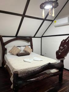 a bedroom with a bed in a room with a ceiling at Monte Verde Hostal in El Zaino