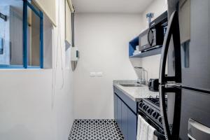 eine kleine Küche mit einem schwarz-weißen Fliesenboden in der Unterkunft Stylish Condesa 2BR w Gym Rooftop MEX-122 in Mexiko-Stadt
