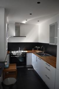 a kitchen with white cabinets and a sink and a stove at Casa Frida in Ostend