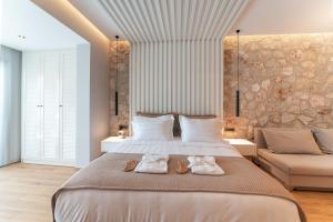 a bedroom with a large bed with two towels on it at THERETRA PEFKI Seaside in Pefki