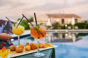 dos bebidas en una mesa junto a una piscina en Nèroli Bio Relais, en Catania