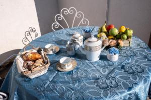 Un posto al sole - Caltanissetta في كالتانيسيتا: طاولة زرقاء مع سلة من الطعام والفواكه عليها