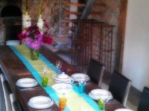 a long table with plates and glasses and flowers on it at Le Chalet Champenois in Bethon