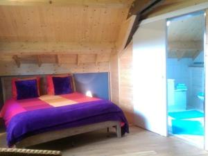 - une chambre avec un lit violet dans l'établissement Le Chalet Champenois, à Bethon