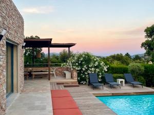 taras ze stołem i krzesłami obok basenu w obiekcie Villa Terra Vecchia, 6 ou 12 personnes, vue imprenable, piscine chauffée w mieście Porto-Vecchio