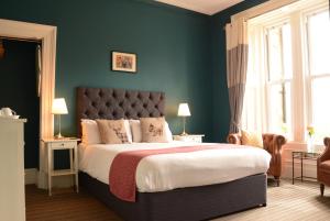 1 dormitorio con 1 cama grande y paredes verdes en Creag Mhor Lodge, en Onich