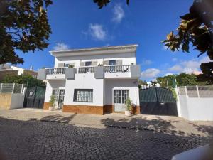 a white house with a balcony on a street at Casa Rocha in Pêra