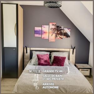 1 dormitorio con 1 cama con almohadas moradas en Suite Rêve - SDB WC Privatif - Entrée autonome - Grande TV NETFLIX, en Compiègne