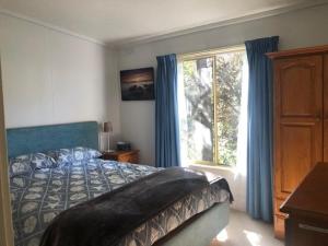 a bedroom with a bed and a large window at Beach Cottage in Ventnor in Ventnor
