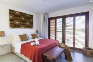 Un dormitorio con una cama con un osito de peluche. en Sensacional flat no Laguna Serena, en Pipa