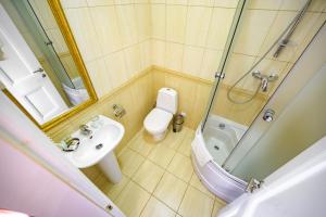 a bathroom with a toilet and a sink and a shower at Gostiniy Dvor in Odesa