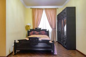 a bedroom with a black bed and a window at Gostiniy Dvor in Odesa