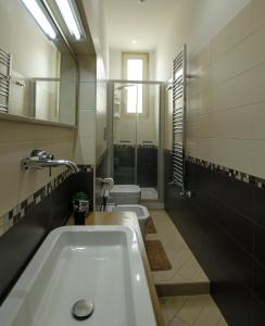 a bathroom with two toilets and a sink and a tub at Refrésh House in Brindisi