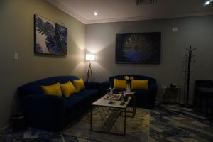 a living room with two blue couches and a table at Swat Hotel Apartments 2 in Al Khobar
