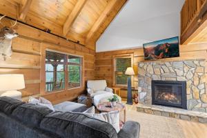 a living room with a stone fireplace in a log cabin at Ridgeview in Blowing Rock