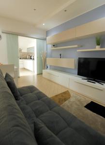 ein Wohnzimmer mit einem Sofa und einem Flachbild-TV in der Unterkunft Refrésh House in Brindisi