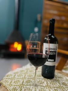 Luxury Holiday Home In Ibiraquera-SC في إيمبيتوبا: كوب من النبيذ الاحمر بجانب زجاجة من النبيذ