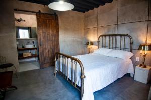 1 dormitorio con 1 cama y puerta de madera en Prajna Valle de Guadalupe en Valle de Guadalupe