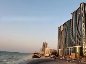 a view of a city with the ocean and buildings at Walk to the Beach, Charming 3-Bedroom Home in Ajman Corniche Residences in Ajman 