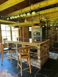 cocina con encimera de piedra, sillas y fogones en Oanduaia saunamaja, en Oandu