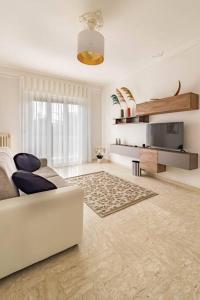 uma sala de estar com um sofá branco e uma televisão em [Apt Green Park] ¤ Best Airport Accommodation ¤ em Bitonto