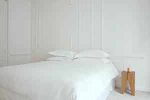 a white bed with white sheets and pillows at La Maison Champs Elysées in Paris
