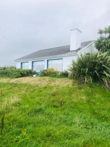 a house sitting on top of a grass field at Tranquilty in Ballyheigue