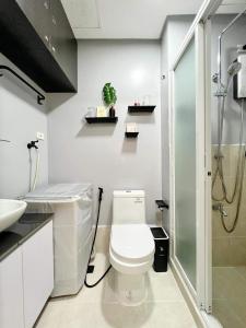 La salle de bains est pourvue d'une douche et de toilettes. dans l'établissement JA1 STAYCATION at TREES RESIDENCE, à Manille