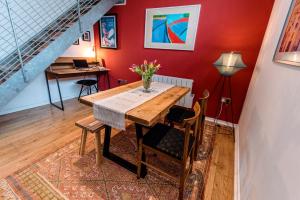a dining room with a wooden table and a red wall at Unique, stylish and secluded home, with parking in the heart of historic York in York